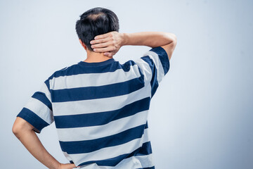 Asian man in navy and white striped t-shirt seen from behind, scratching head with one hand and...