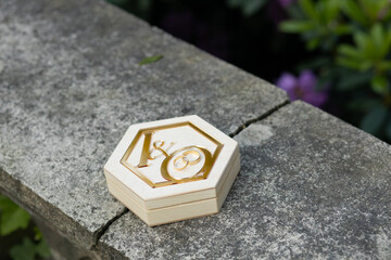 Wooden box for wedding rings. On the wooden box as decoration are golden letters I and O. In the...
