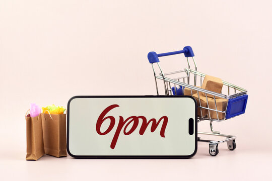 The shopping cart with a smartphone there is 6pm open on the screen on white background.