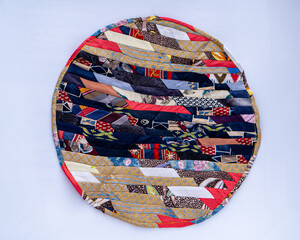 Patchwork. A fragment of multi-colored pieces of fabric sewn together. Round rug.