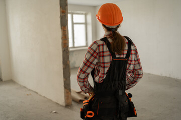 Rear view of builder or construction worker looking on old apartment. House improvement