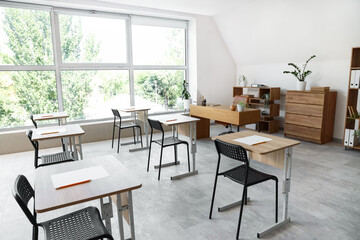 Interior of stylish empty classroom prepared for exam