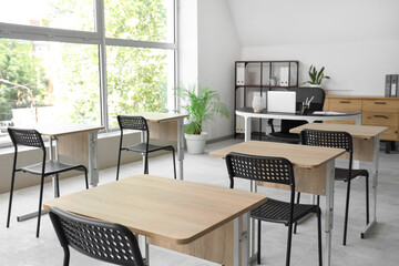 Desks and chairs in empty classroom at school