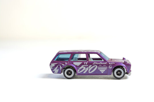 Lins, s&atilde;o paulo, brazil - july 10 2025:  a purple datsun station wagon toy car with white stripes on a white background in studio shot
