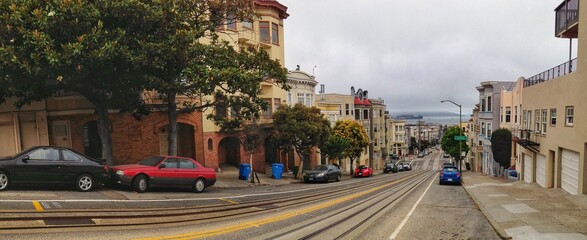 Panoramic view of a city street descending towards the distant harbor