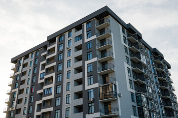 Fototapeta premium Modern architecture showcases urban living in a newly constructed apartment building against a cloudy sky during late afternoon