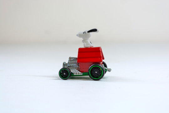 Lins, s&atilde;o paulo, brazil - july 10 2025:  snoopy on top of his dog house riding on a hot wheels car on a white background in a studio shot
