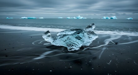 Shimmering Ice Chunk on Black Volcanic Sand Beach with Icebergs in the Distance