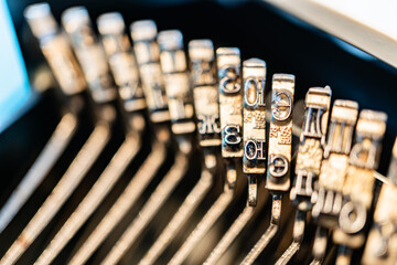 Close-up image of typewriter keys arranged in a grid, highlighting their metallic shine and...