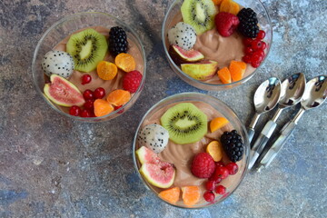 Silken tofu chocolate mousse dessert with mixed fresh fruits ( kiwi, dragon fruit, raspberry, blackberry, fig, orange, red currant, physalis). Vegan dessert