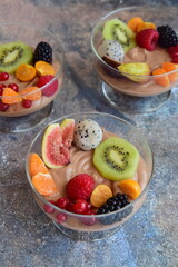 Silken tofu chocolate mousse dessert with mixed fresh fruits ( kiwi, dragon fruit, raspberry, blackberry, fig, orange, red currant, physalis). Vegan dessert
