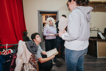 A group of young performers preparing and rehearsing for a theatrical presentation. The image...