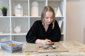 Young female artist in an art studio painting an original deer artwork