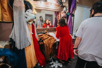Vibrant scene depicting young actors selecting costumes in a theater backstage, emphasizing their...