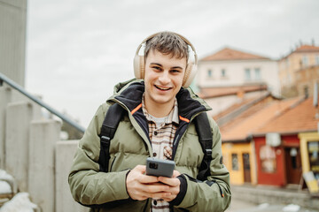 Fototapeta premium Young adult caucasian man student smile and use phone to take self portrait or video call 