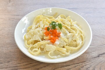 steamed salmon fettuccine alfredo with white cream sauce topping shrimp egg on plate  