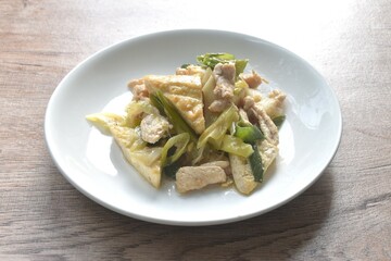 fried slice tofu and chicken with garlic chive in soy sauce on plate