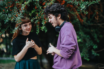 A young man and woman engage in a friendly conversation under lush foliage, creating a lively and...