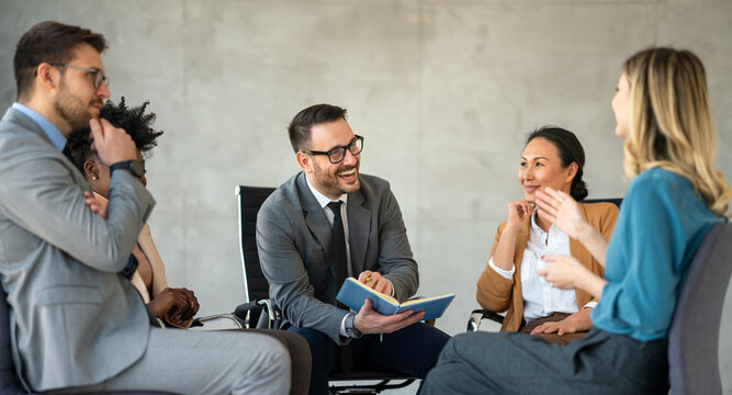 Team of colleagues sitting in office and listening to coach sharing his advice and expertise