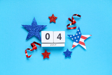 Cube calendar with date of Independence Day, stars and serpentines on blue background