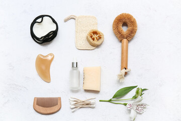 Cotton pads, guasha, flower and bath supplies on light background