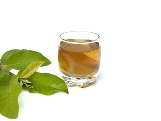 Guava leaf boiled water in glass and fresh guava leaves. Healthy drink lifestyle