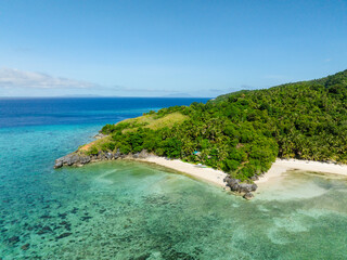 Sandy beach with turquoise sea water and corals. Cobrador Island. Romblon, Philippines.