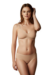 Fototapeta premium A woman in soft beige lingerie smiling gently, isolated 