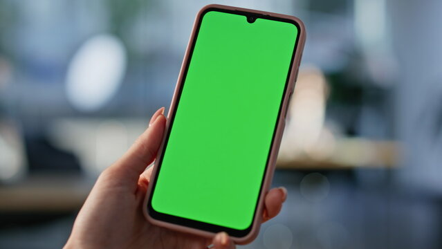 User hand holding mockup smartphone at office closeup. Unrecognizable woman