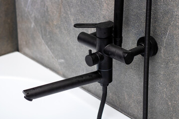 A sleek black faucet featuring a hose that is firmly attached to it