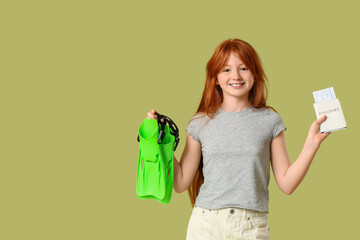 Cute girl with flippers and passport on green background. Travel concept