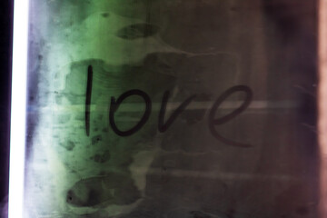 The word love is beautifully written on a green and black background