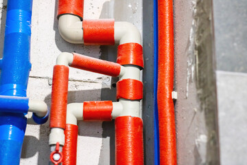 This is a detailed closeup view of red and blue pipes against a wall