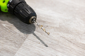 This is a detailed close up image of a drill bit placed on a wooden surface