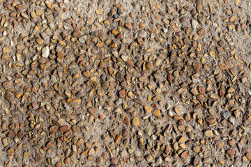 Close-up view of small stones and gravel aggregate on a walkway surface, showcasing texture and natural patterns—ideal for backgrounds, construction themes, and material design concepts