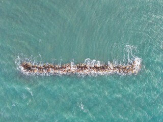 Aerial View of Coastal Rock Formation Above Turquoise Sea