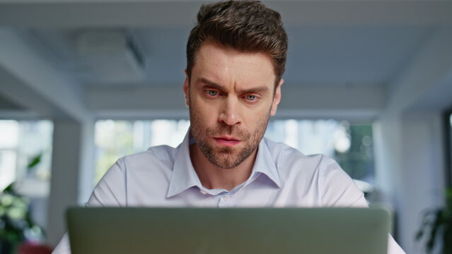 Closeup tensed freelancer working laptop at modern workplace. Frowned manager