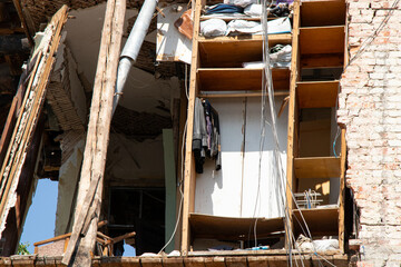 Destroyed residential building after missile strike in Ukraine, collapsed wall and damaged floors, consequence of war