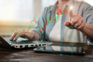Man using laptop to analyze stock market charts and financial data in real time for investment decisions