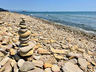 Pyramid of stones in the bay of Akhlestyshev on Russian island in summer. Vladivostok