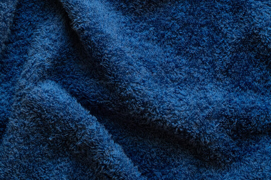 Terry dark blue towel close-up, soft fabric texture with loops, cotton material