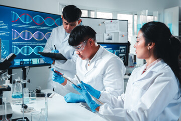 A diverse group of young scientists collaborate in a modern lab, examining a petri dish with bacterial cultures while taking notes, emphasizing teamwork, research, and scientific discovery.