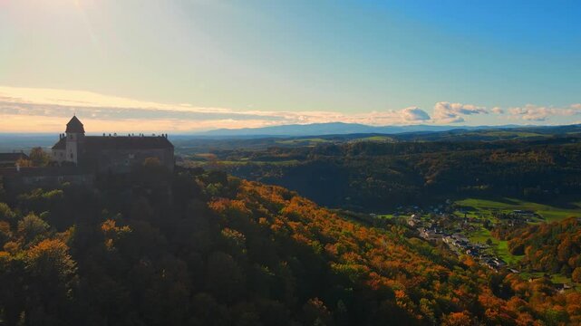 Aerial view of the historic Bernstein Castle (Burg Bernstein) in Austria. Scenic drone shot of the medieval fortress surrounded by forest and hills in the Burgenland region. 
