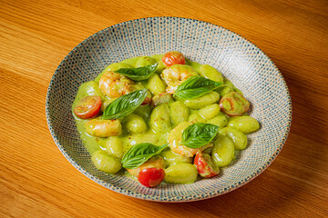 Delight in tender gnocchi paired with vibrant pesto, juicy cherry tomatoes, and fresh basil
