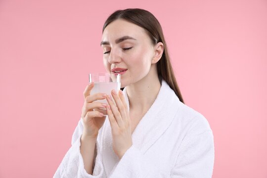 Woman drinking collagen water on pink background - Powered by Adobe