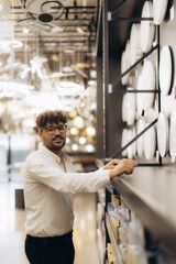 Man Browsing Lighting Store with Modern Fixtures and Elegant Displays