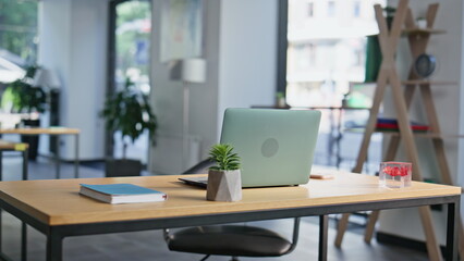 Modern coworking workspace laptop on wooden desk closeup. Organized work table