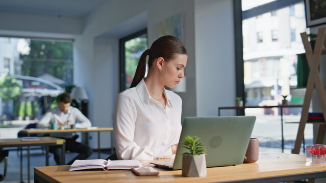 Joyful employee satisfied successful work reading financial report at office.