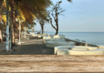 Wooden table top on the beach or sea and coconuttrees .Party on the beach  daytime concept.For montage product display or design key visual layout.View of copy space.