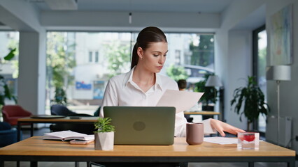 Professional accountant reading documents at coworking workspace closeup. 